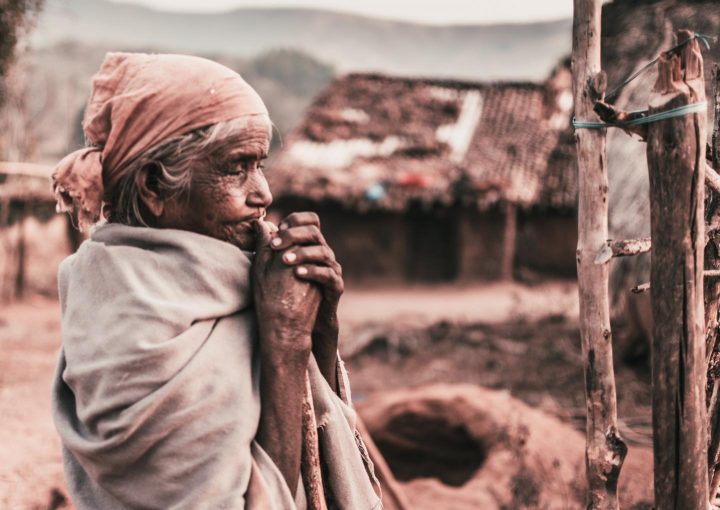 Uma mulher pobre e idoso orando